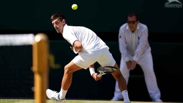 Djokovic salva una bola por debajo de las piernas en Wimbledon