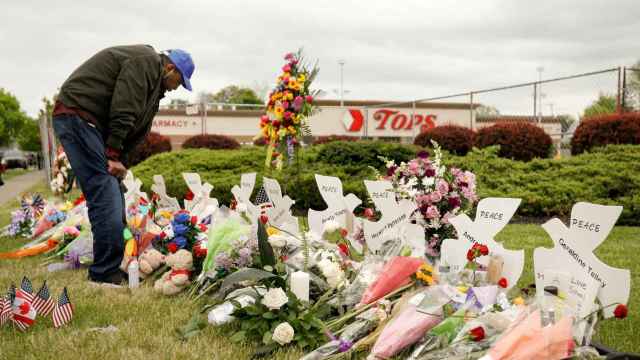 Un hombre deja flores en el lugar del tiroteo de Buffalo, EEUU.