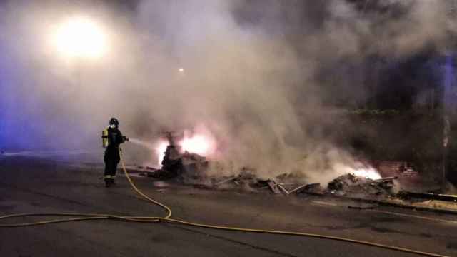 Los bomberos sofocando el fuego de los contenedores de León