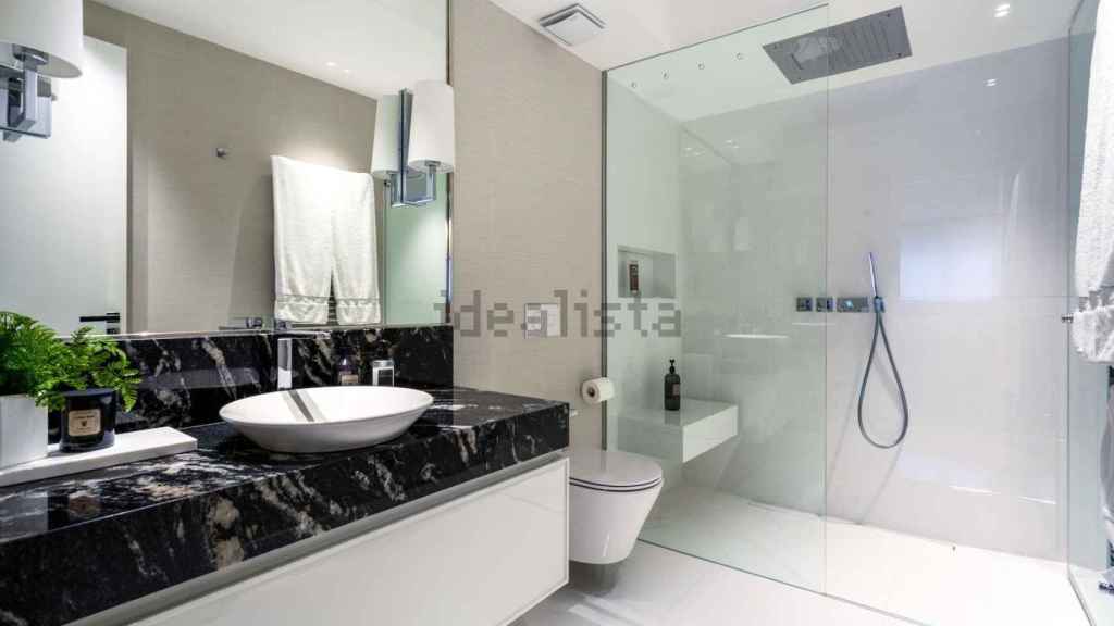 El cuarto de baño destaca por la amplia ducha y sus líneas pulidas.