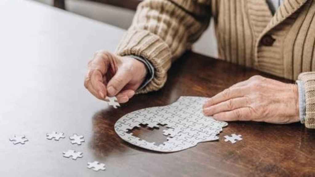 Un anciano resuelve un puzle.