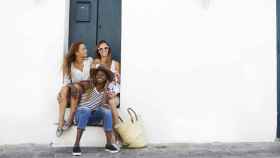 Tres amigas sentadas en una puerta en Ibiza