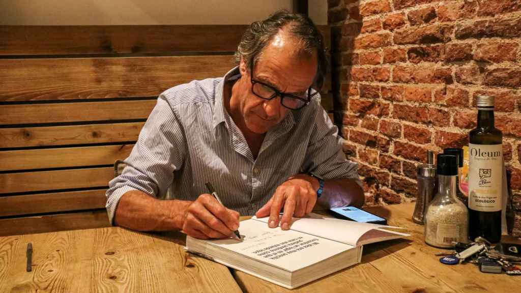 Alain Coumont firma un ejemplar de un libro en una de las mesas del Le Pain Quotidien de Serrano
