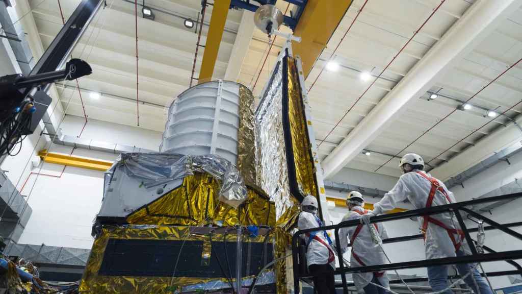 Varios científicos ensamblan paneles solares al satélite Euclid en una planta en Turín