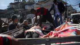 Los moradores de la favela subiendo los muertos a una furgoneta.