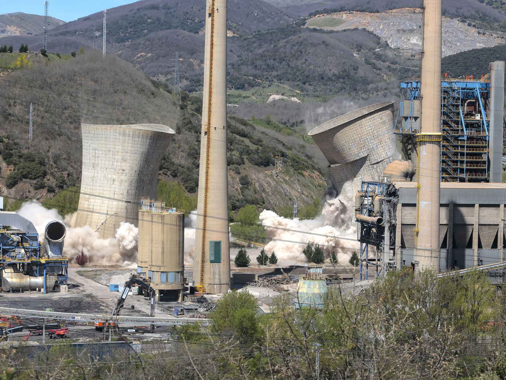 Imagen en primer plano de las dos chimeneas de La Robla durante el derribo de las dos torres de refrigeración, el pasado 6 de mayo.