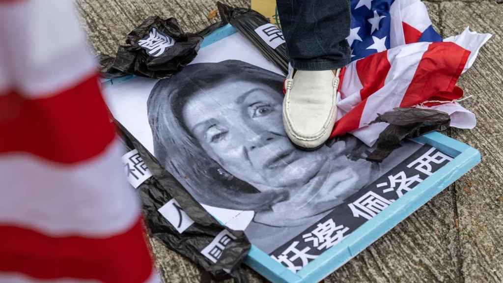 Un grupo demanifstantes pro-China pisa una foto de la presidenta de la Cámara de Representantes de los Estados Unidos, Nancy Pelosi,