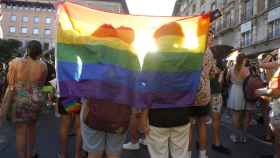 Dos personas se tapan con una bandera durante una manifestación por el Orgullo LGTBI, a 28 de junio de 2022, en Palma de Mallorca, Baleares.