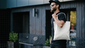 Foto de archivo de un chico paseando con una 'tote bag'.