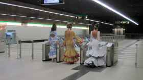 Tres mujeres vestidas de gitana entran en el Metro de Málaga.