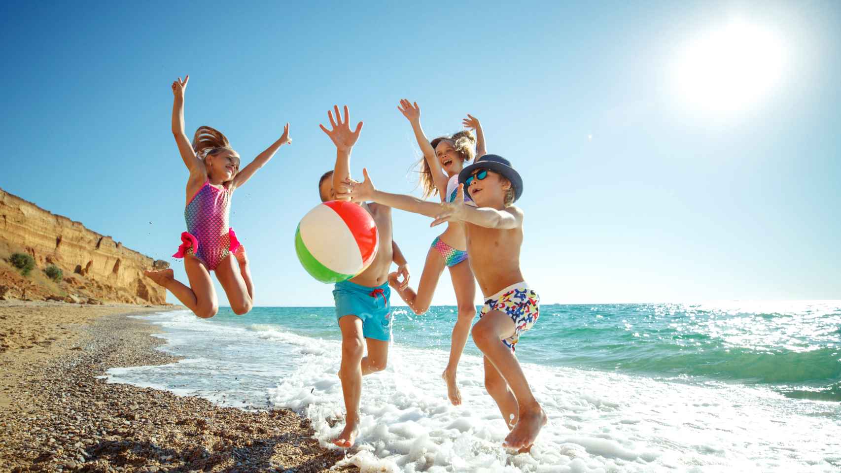Un grupo de niños disfruta en la playa.