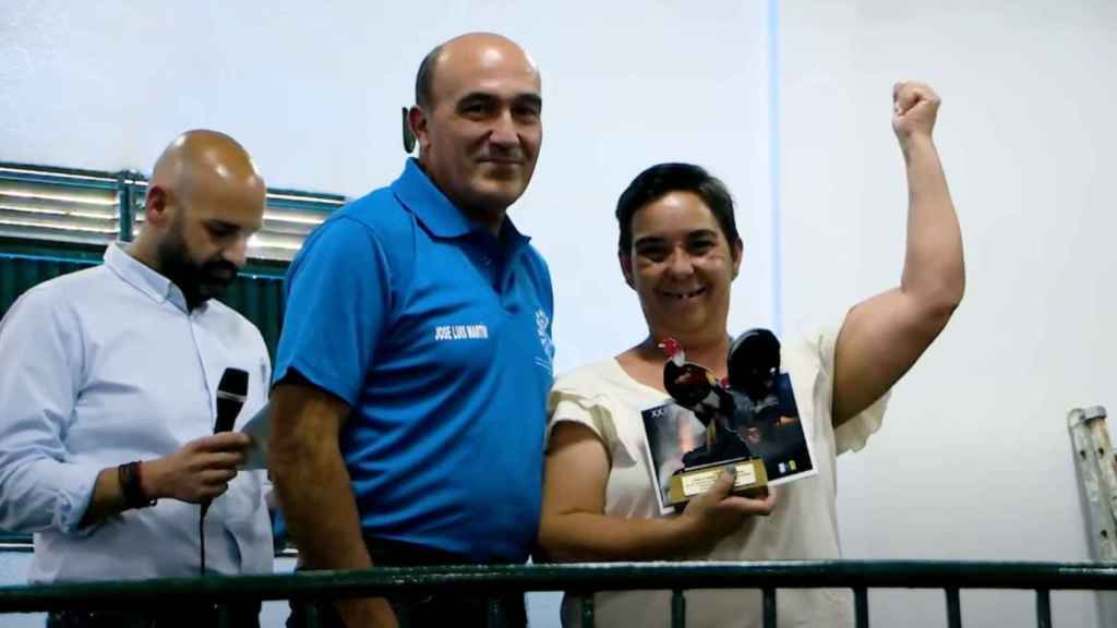 José Luis haciendo entrega de un trofeo de reconocimiento para las mujeres dedicadas a la cría de gallos.