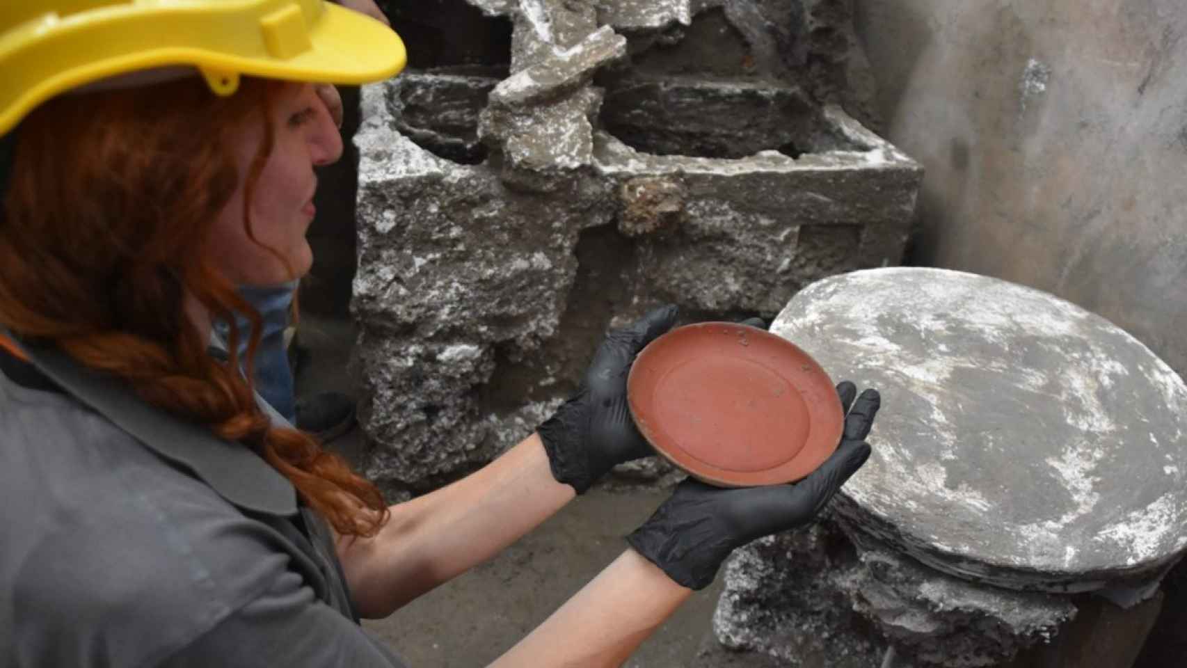 Una de las arqueólogas sostiene el plato de 'terra sigillata'.