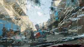 Varios palestinos, fotografiados desde un coche dañado por los bombardeos de Israel sobre la Franja de Gaza
