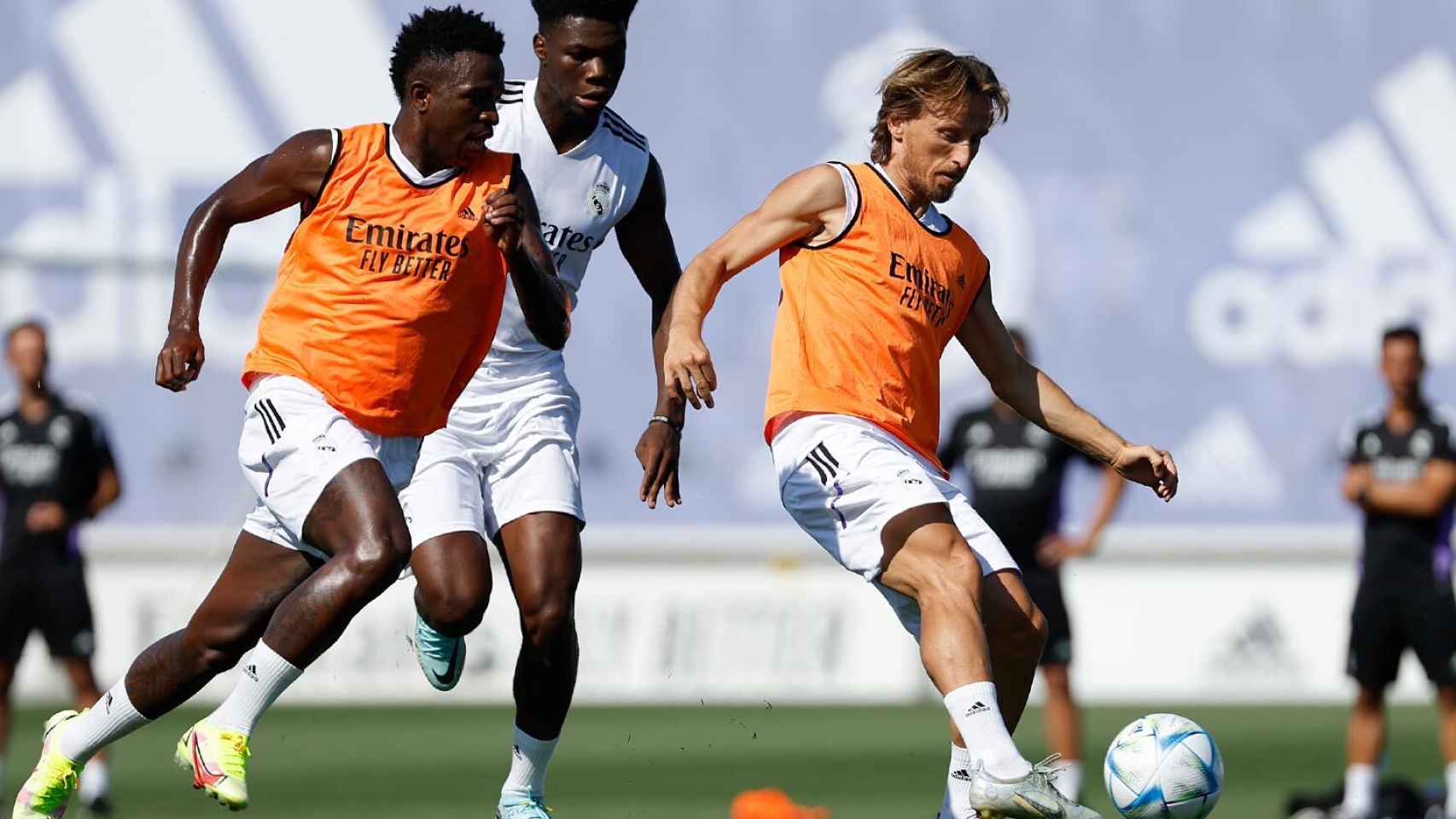 Luka Modric pasa el balón con el exterior de su pie derecho delante de Aurélien Tchouaméni y Vinicius Júnior.