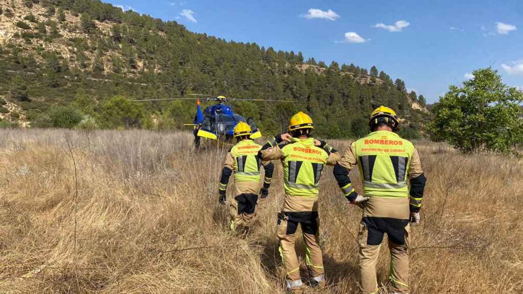 Bomberos de la Diputación de Cuenca junto a un helicóptero medicalizado en la Chorreras del Cabriel.