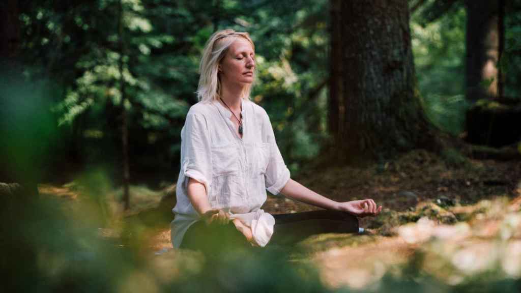 Mujer practicando meditación en el campo.