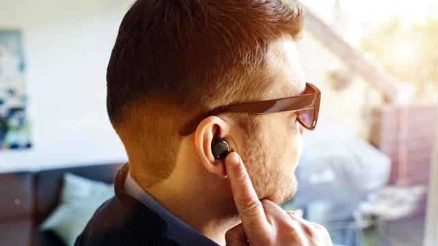 Un hombre escucha música con sus auriculares tipo earbuds.