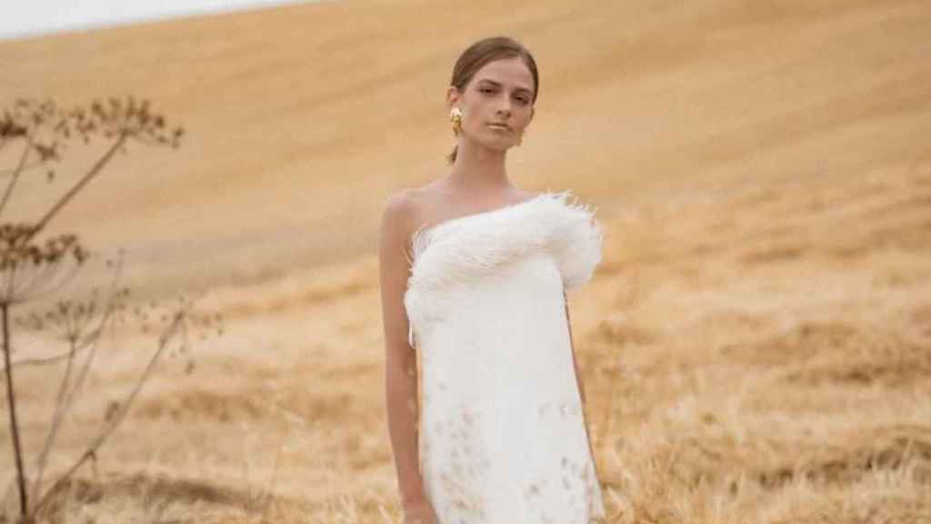 Un vestido de novia con plumas en su escote.