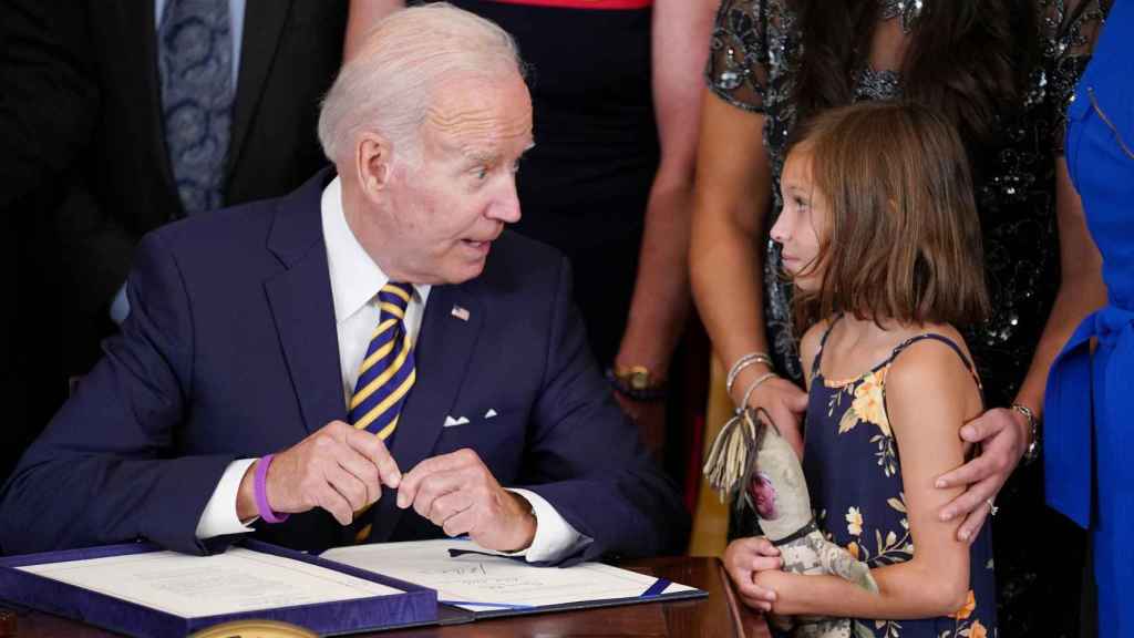 Joe Biden en su despacho de la Casa Blanca junto a una niña.