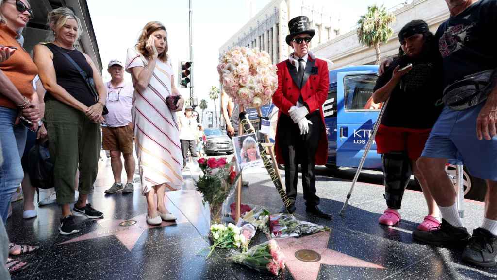 Los paseantes rodean la estrella de la fama de Olivia Newton-John en Hollywood, Los Angeles.
