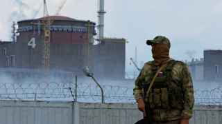Un militar con una bandera rusa en su uniforme hace guardia cerca de la planta de energía nuclear de Zaporiyia.