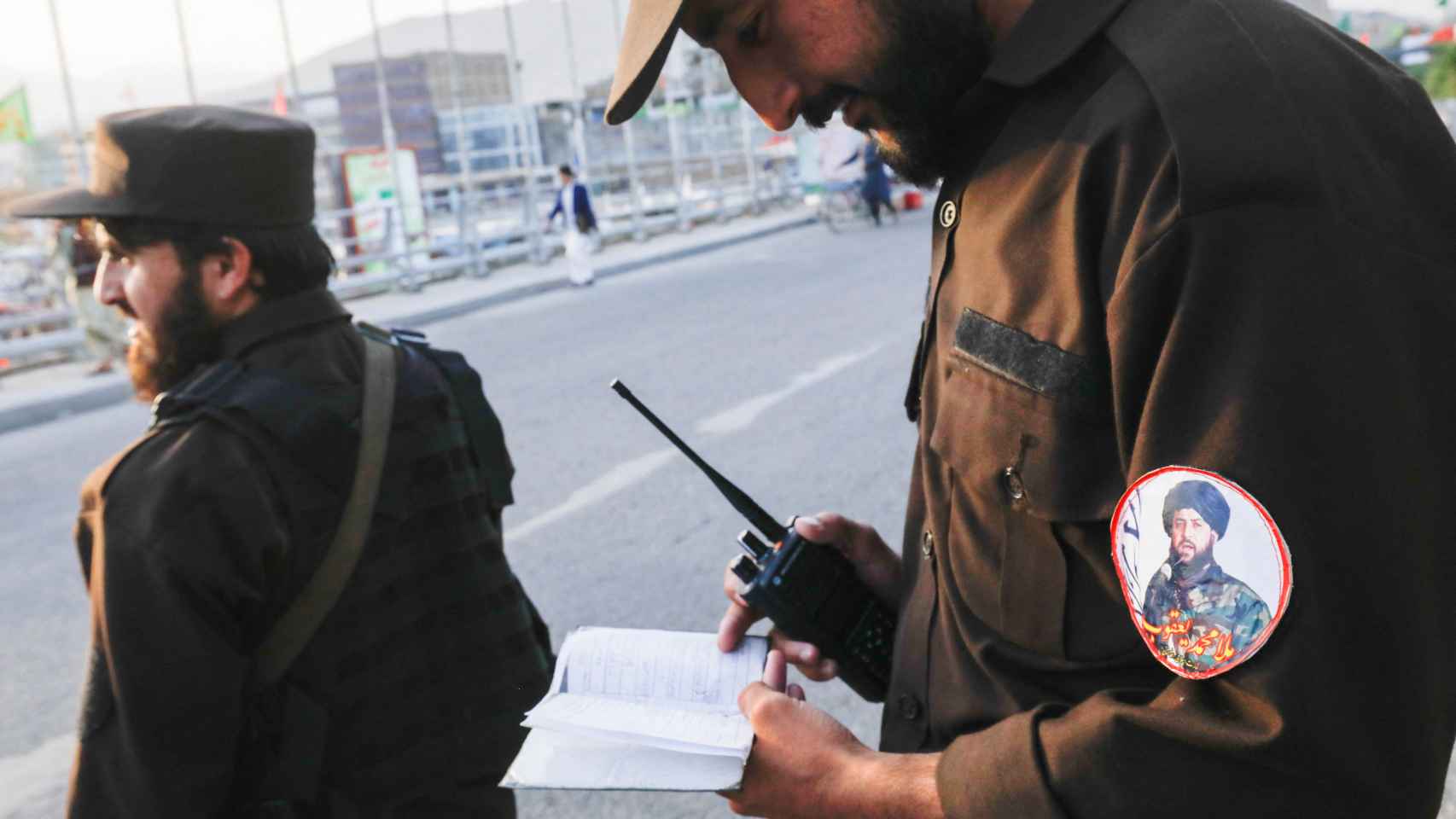 Un policía en Kabul con la foto en el brazo del ministro interino de Defensa talibán, el Mullah Mohammad Yaqoob.