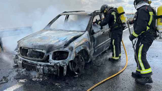 Los bomberos de León apagando el fuego del coche calcinado