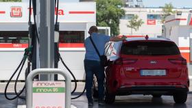 Un pasajero reposta en una gasolinera