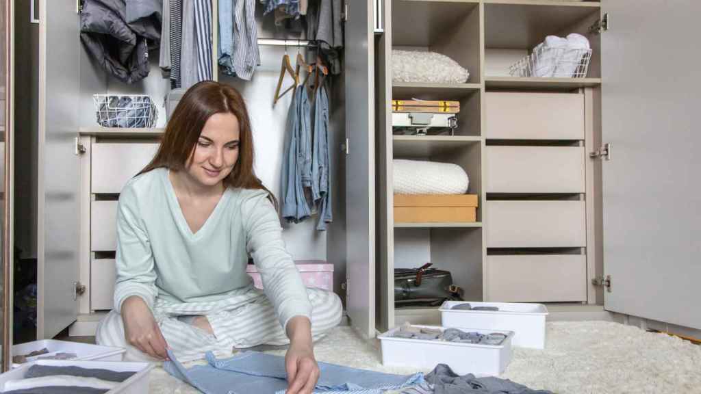 Una mujer ordenando su armario siguiendo el método Marie Kondo.