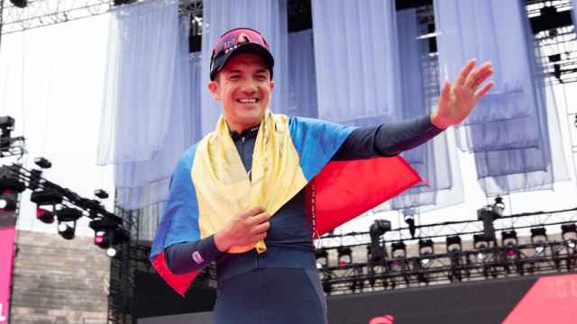 Richard Carapaz celebrando una victoria con la bandera de Ecuador