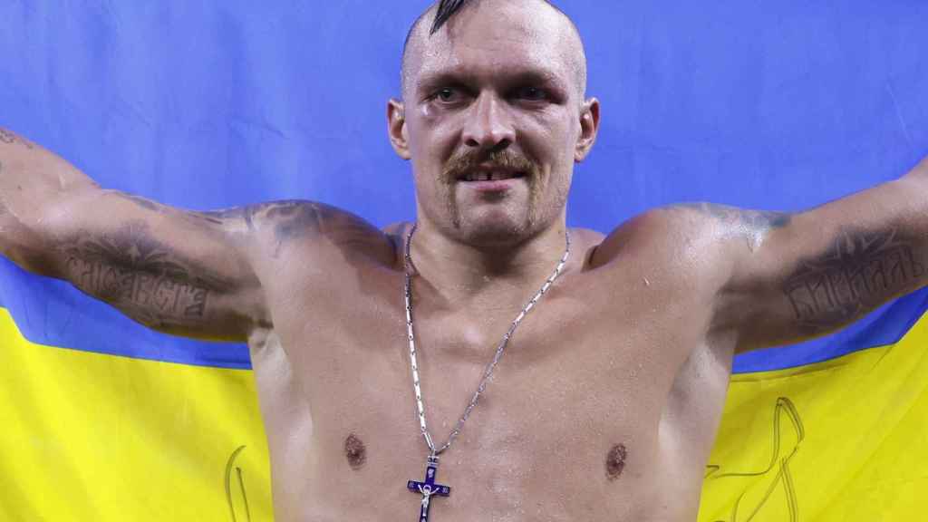 Oleksandr Usyk, con la bandera de Ucrania tras retener sus tres cinturones de campeón del peso pesado en 2022