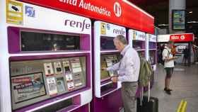 Una persona en una de las máquinas de venta de billetes en la estación Madrid-Atocha Cercanías.