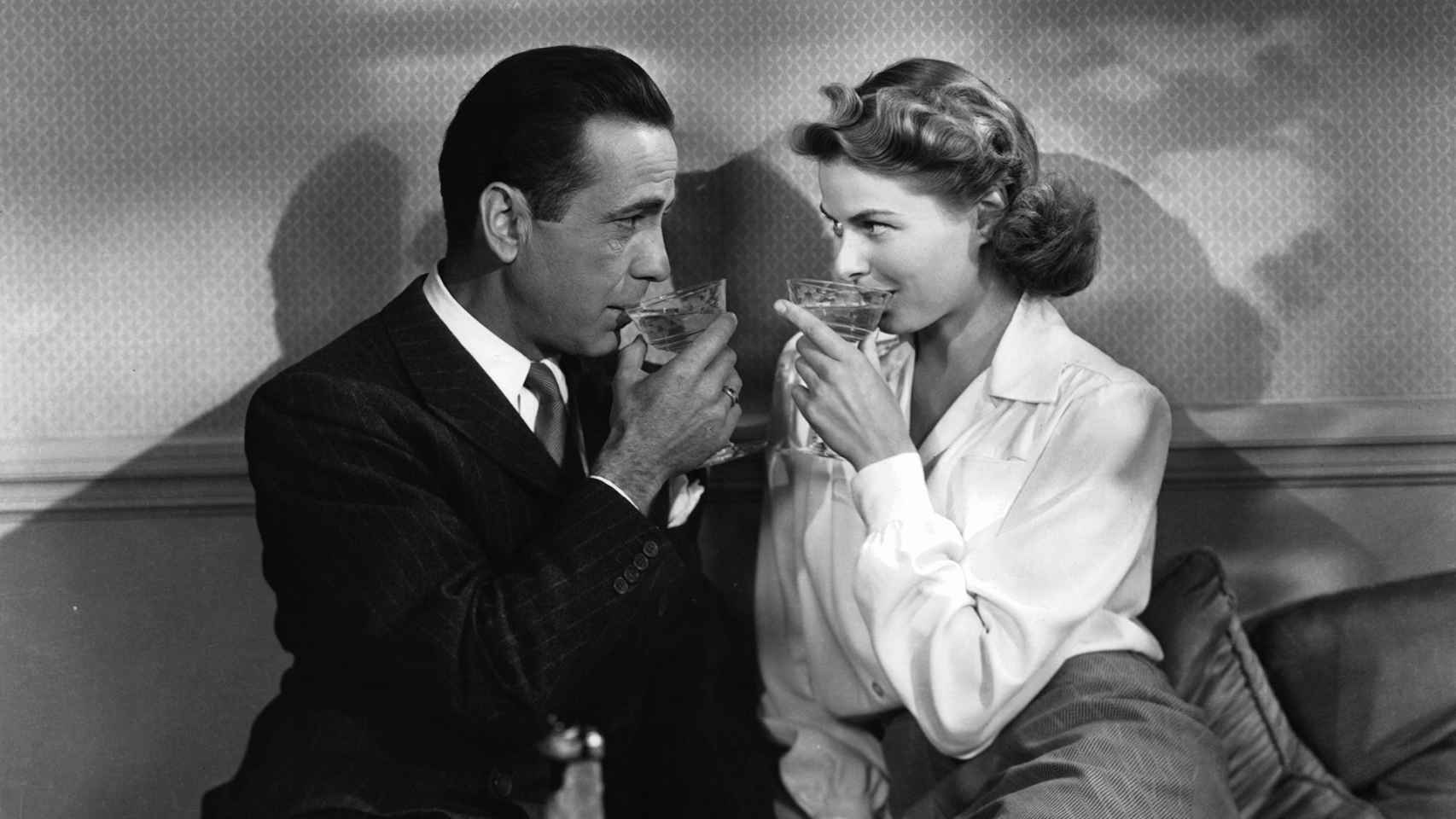 Humphrey Bogart, que aseguró que no se fiaba de quien no bebía alcohol, tomando una copa junto a Ingrid Bergman en una escena de 'Casablanca', película dirigida por Michael Curtiz