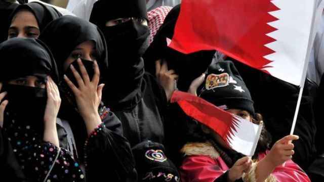 Mujeres de Qatar con banderas del país