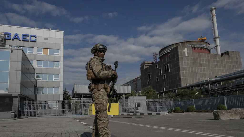 Un soldado ruso hace guardia frente a la puerta principal de la central y junto al reactor 1.