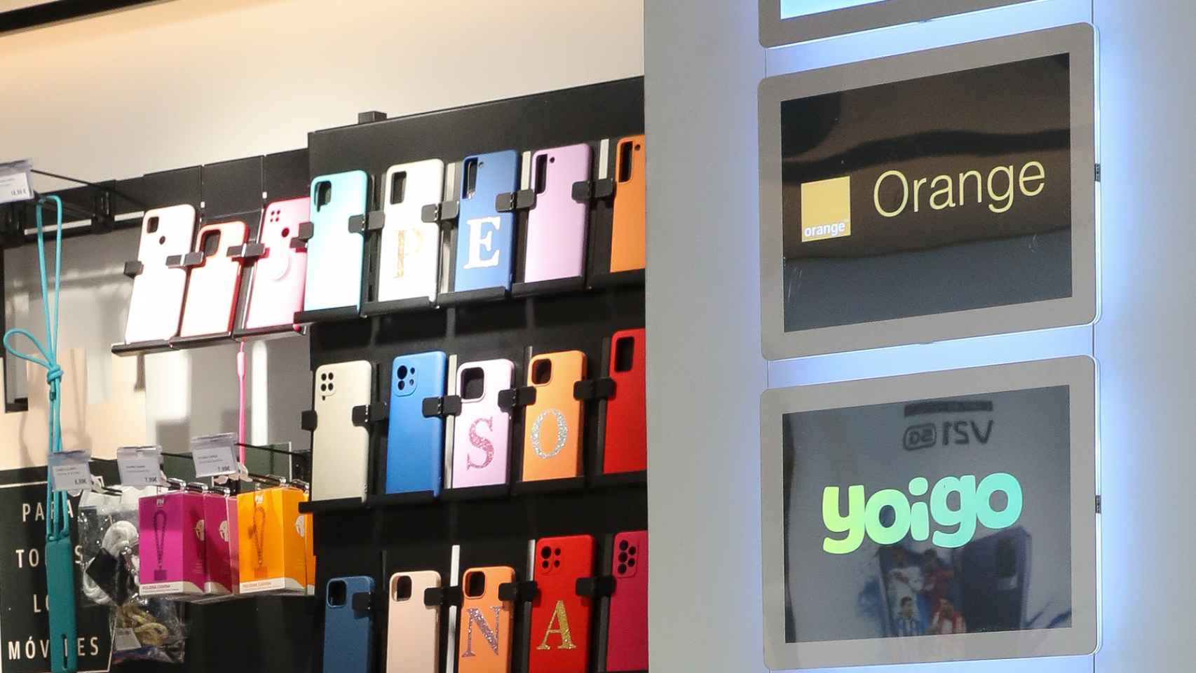 Imagen de los logos de Orange y Yoigo (marca del grupo MásMóvil) en una tienda de telefonía.