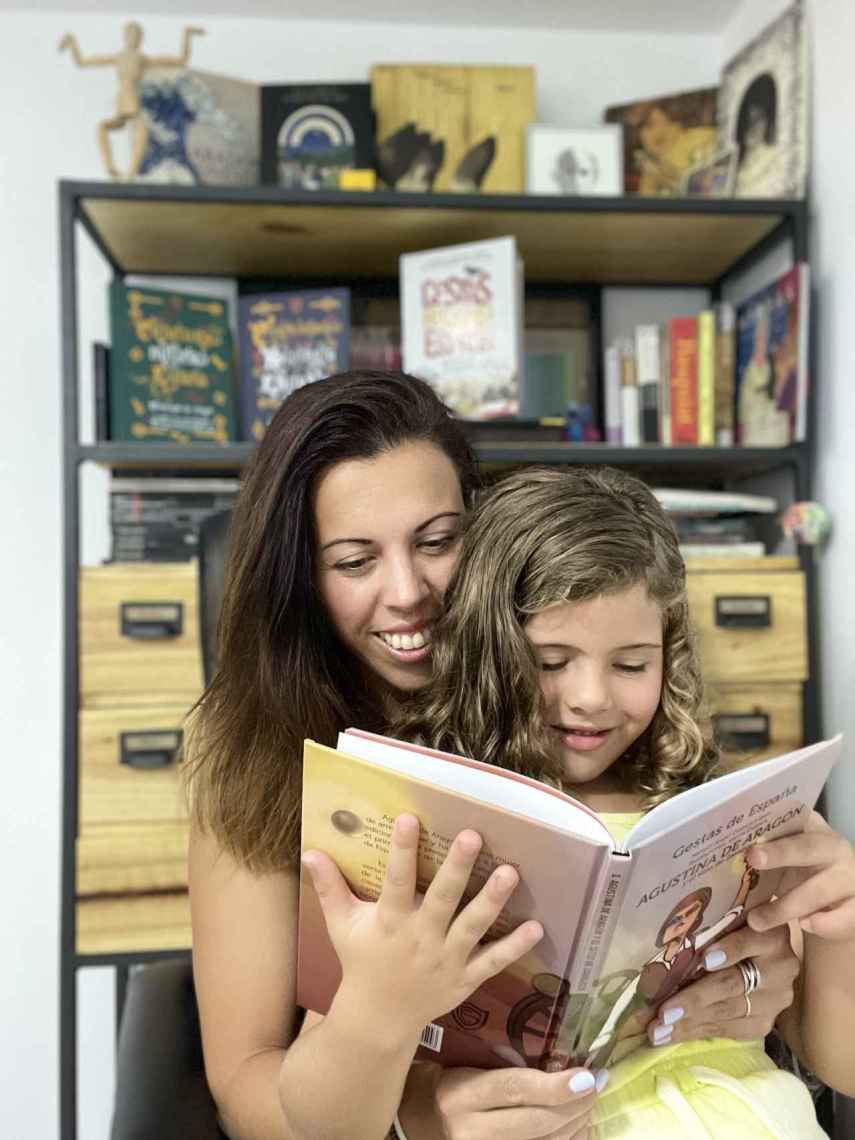 Gloria Cuenca lee 'Gestas de España' junto a su hija Mía.