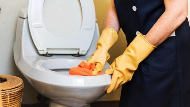 Una persona limpiando el baño.