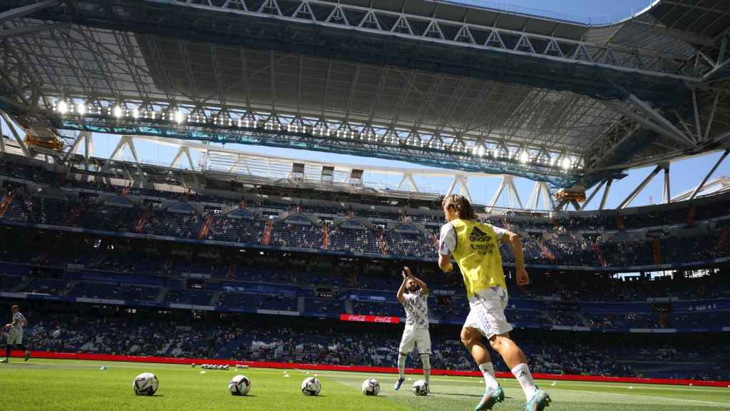 Modric y Benzema saltando a calentar al césped del Santiago Bernabéu