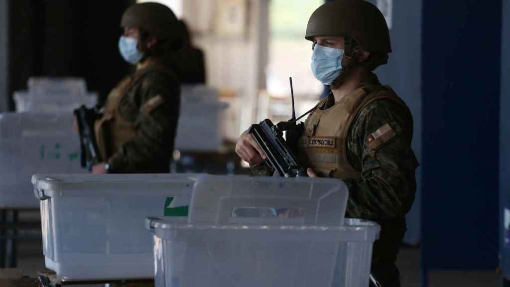Unos militares chilenos custodian un colegio electoral.