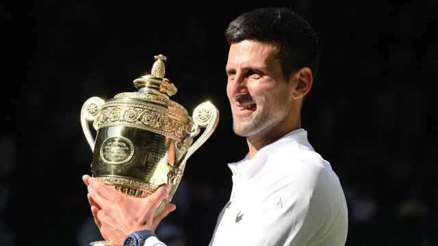Novak Djokovic con el título de Wimbledon.