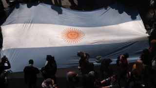 Manifestantes portan una bandera de Argentina.