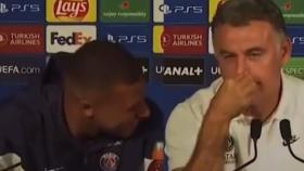 Mbappé y su entrenador riéndose en rueda de prensa.