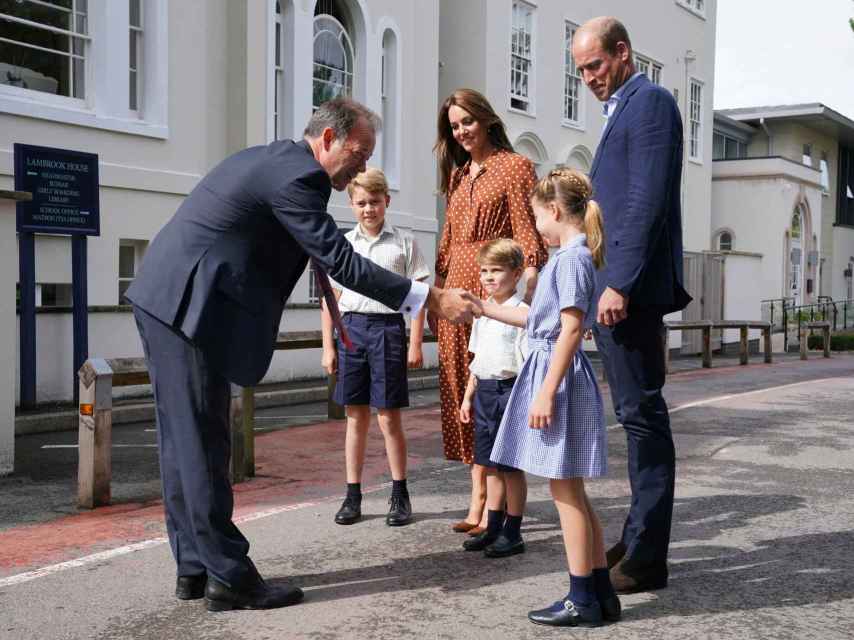 El director del colegio saludando a los hijos de los duques de Cambridge.