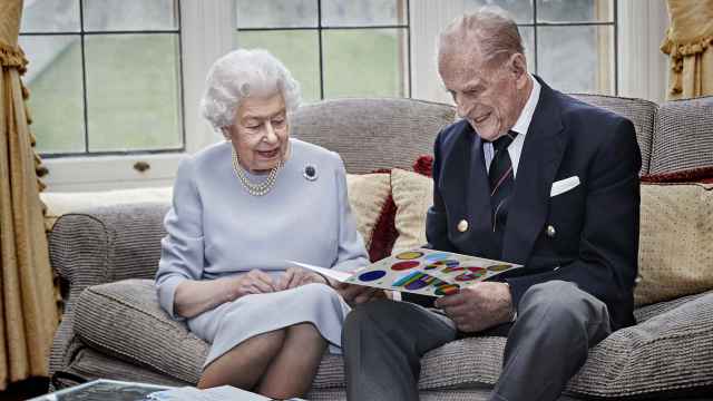 La reina Isabel II y el duque de Edimburgo observan una tarjeta hecha a mano, regalo por su aniversario de bodas.