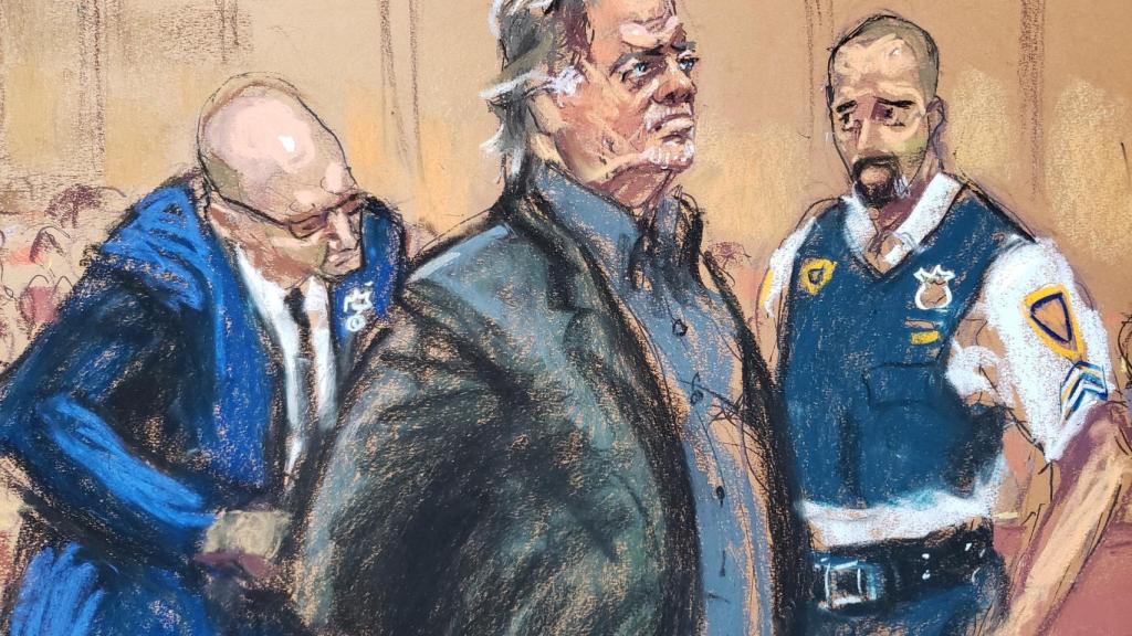 Steve Bannon espera a que le quiten las esposas para la lectura de cargos.