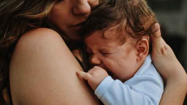 Un bebé llora en los brazos de su madre