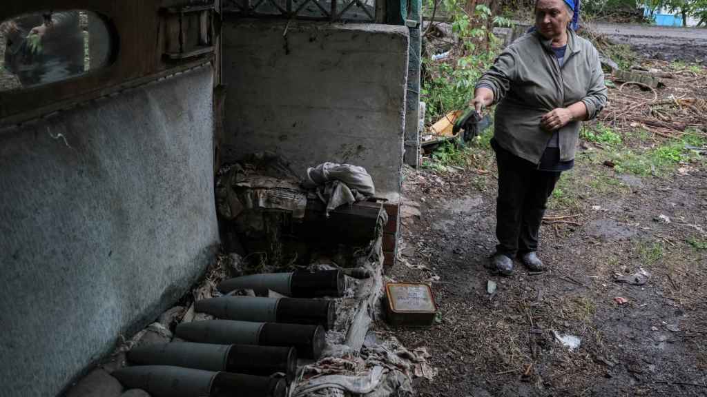 Una mujer señala los misiles que han destruido su casa en Járkov.