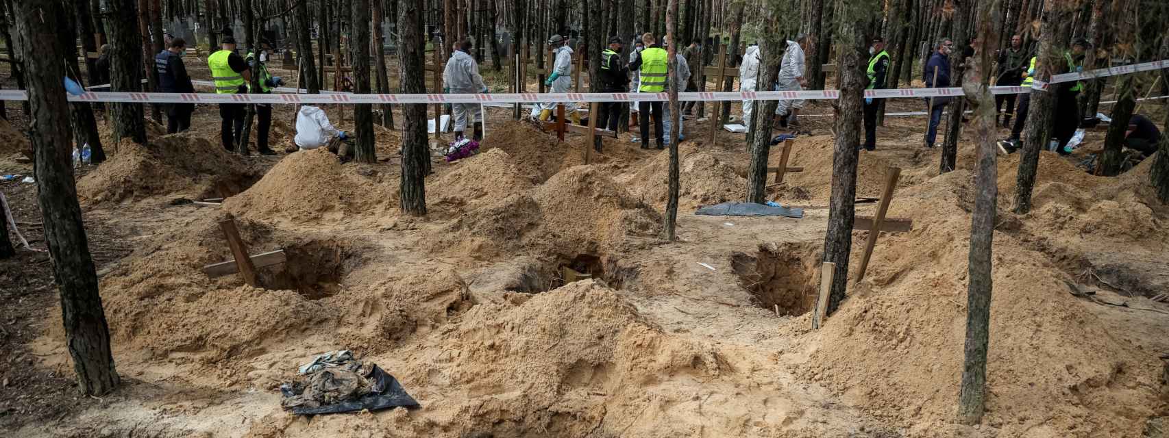 Policías y expertos trabajan sobre una de las fosas comunes halladas en la ciudad de Izium, en Ucrania